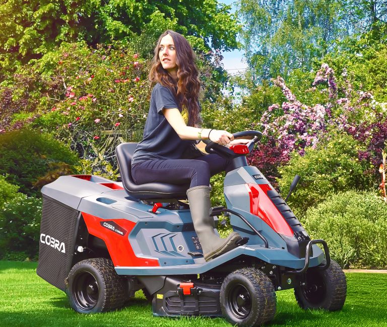 Cobra LTX66HRL 26” Hydrostatic Lawn Rider pictured with a woman riding along on it