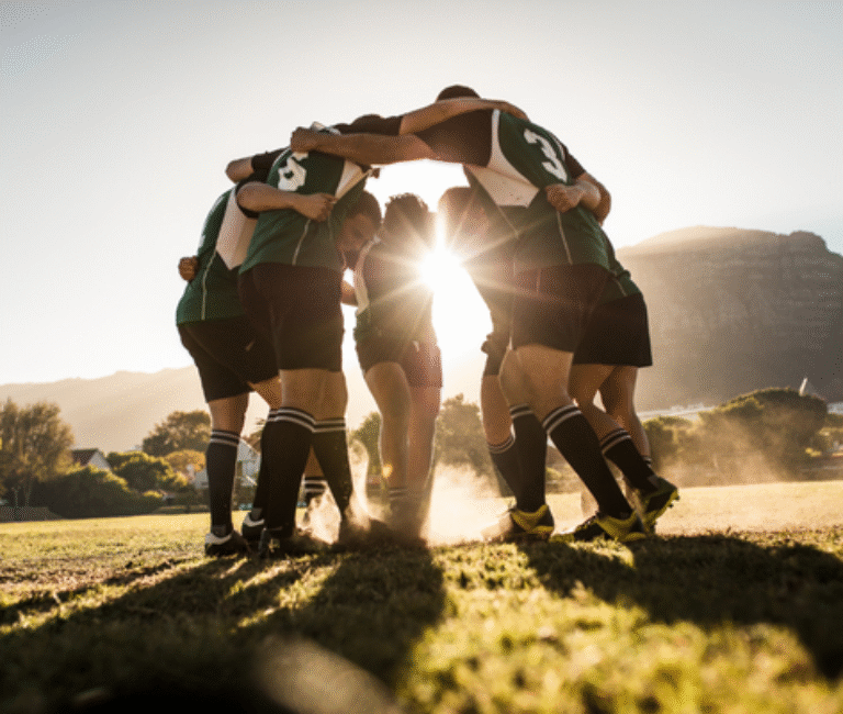 A team huddle at a sporting event representing teamwork and community