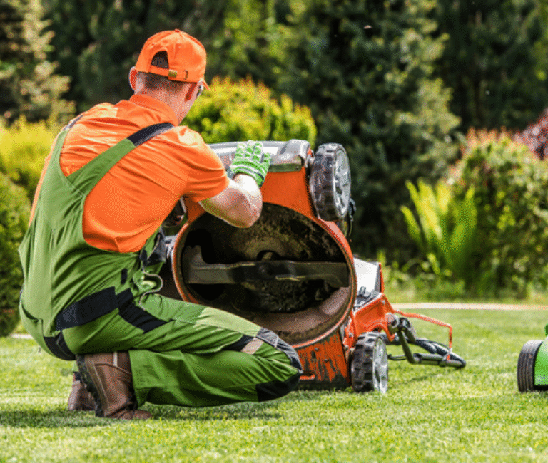 a man holding his lawn mower up to inspect the blades